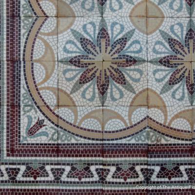 A c.15m2 mosaic themed ceramic floor with lush borders