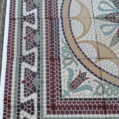 A c.15m2 mosaic themed ceramic floor with lush borders
