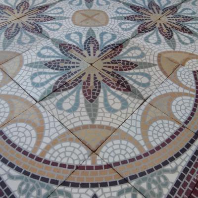 A c.15m2 mosaic themed ceramic floor with lush borders