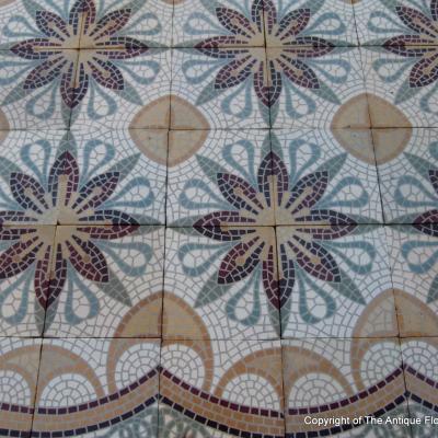 A c.15m2 mosaic themed ceramic floor with lush borders