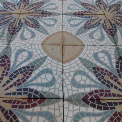 A c.15m2 mosaic themed ceramic floor with lush borders