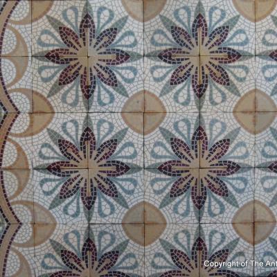 A c.15m2 mosaic themed ceramic floor with lush borders