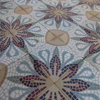 A c.15m2 mosaic themed ceramic floor with lush borders