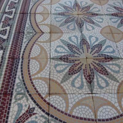 A c.15m2 mosaic themed ceramic floor with lush borders