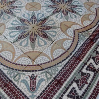 A c.15m2 mosaic themed ceramic floor with lush borders